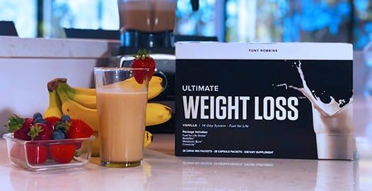 a box of ultimate weight loss is sitting on a counter next to a glass of milk .