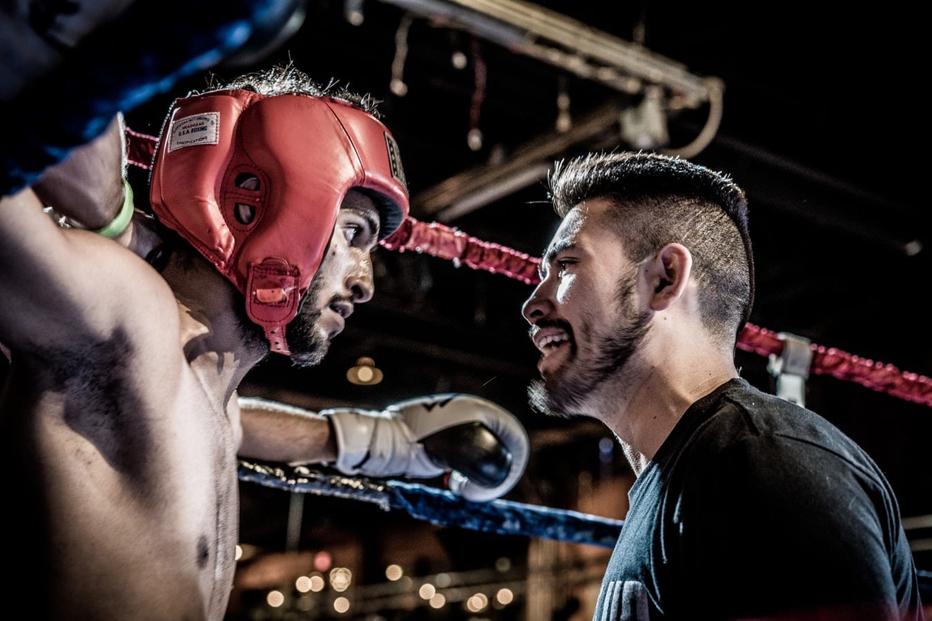 two men are standing in a boxing ring looking at each other .
