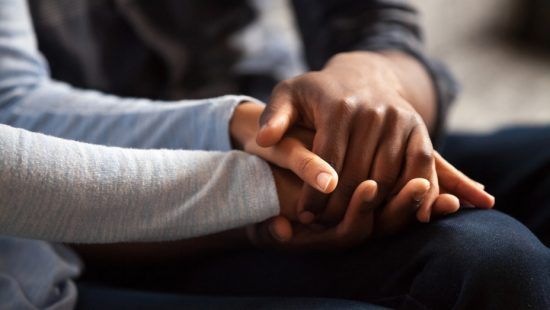 Close-up of two people holding hands