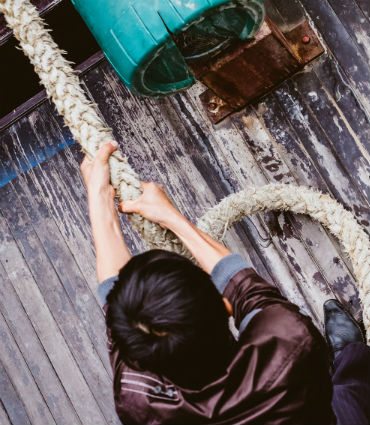 What’s your secret identity? Image of man pulling on thick rope