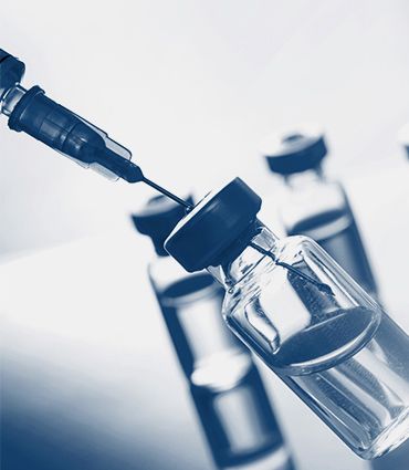 Affordable, scalable, and accessible image of a syringe is being inserted into a bottle of vaccine .