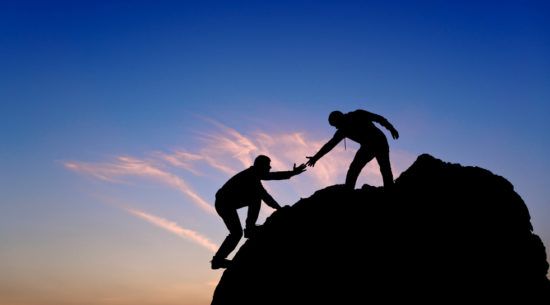 Silhouette of a man helping another man