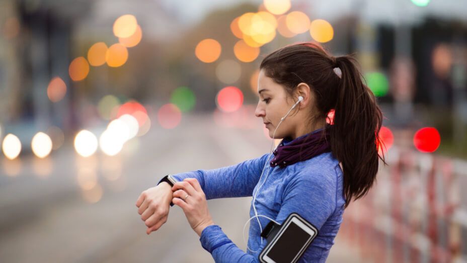 a woman is looking at her smart watch while listening to music .