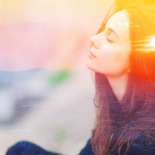 a woman is sitting in a lotus position with her eyes closed .