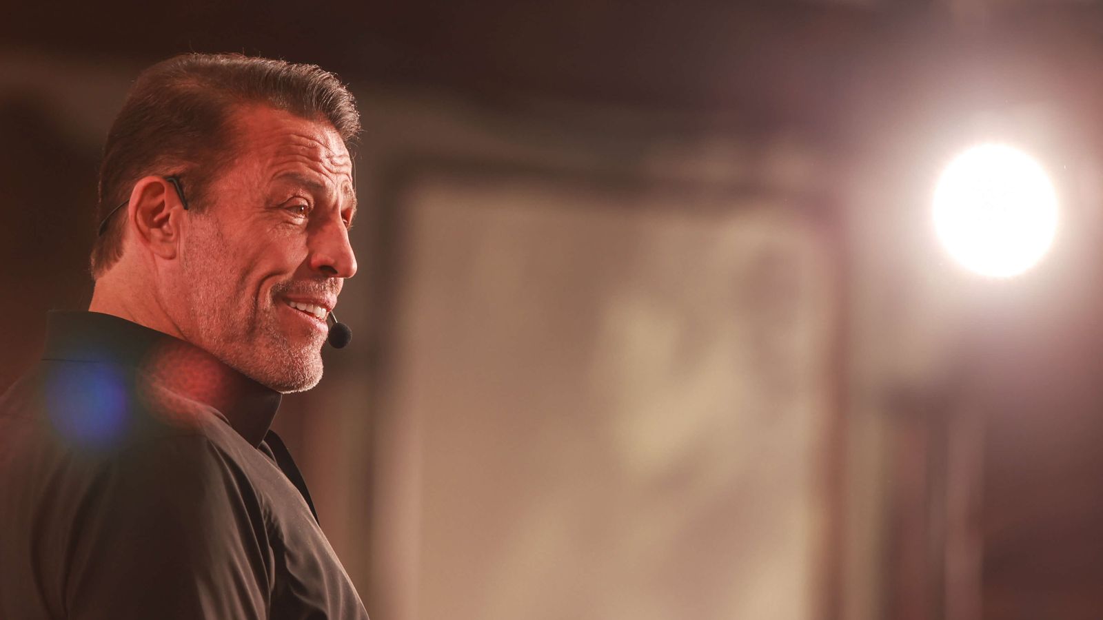 a man is standing in front of a microphone on a stage .