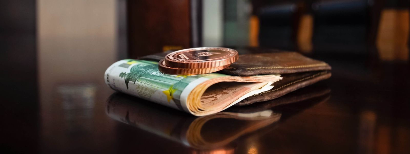 Master the current financial landscape image of a wallet filled with money and coins on a table