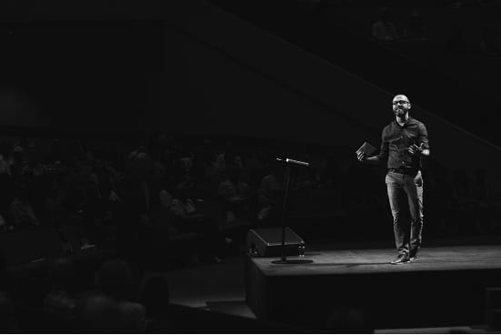 a man is standing on a stage in front of a microphone .