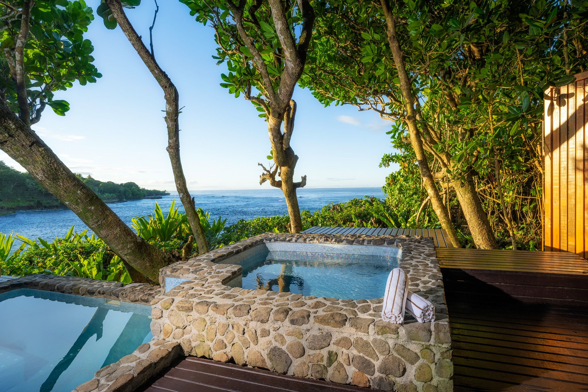 there is a hot tub with a view of the ocean .