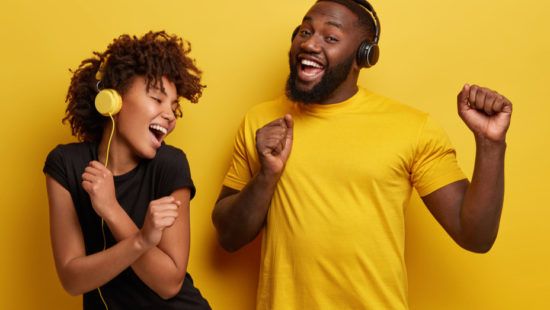 a man and a woman wearing headphones are dancing together .