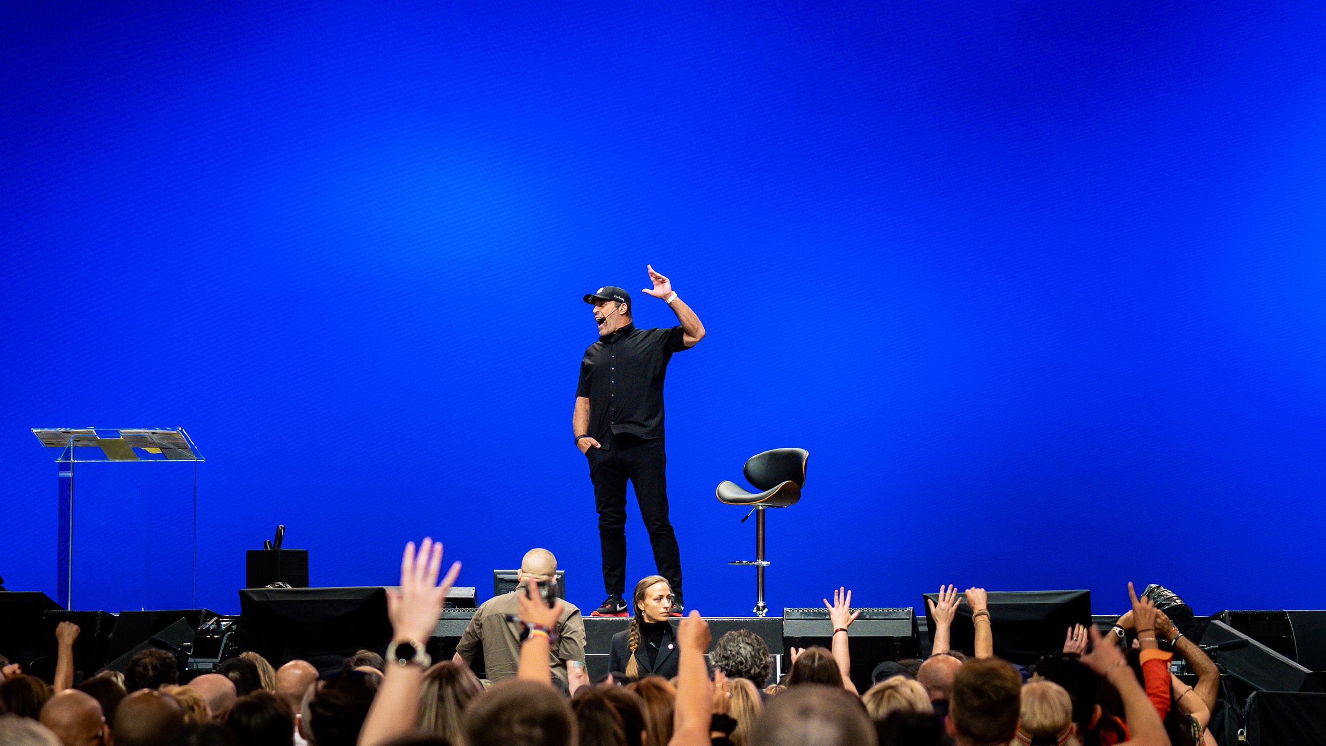 a man is standing on a stage in front of a crowd of people .