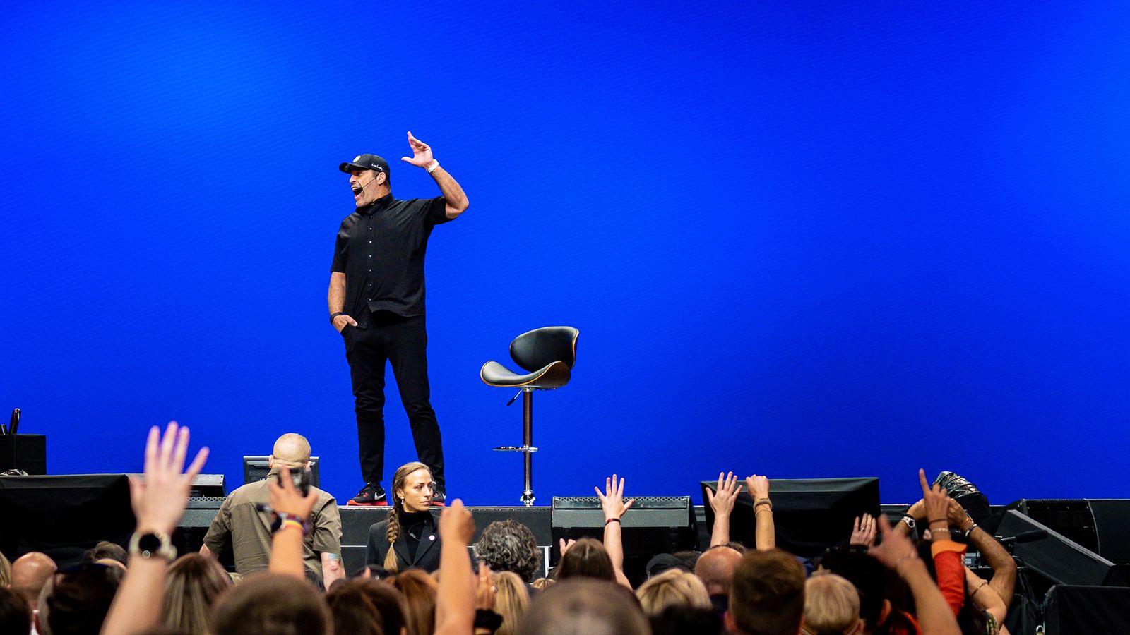 a man is standing on a stage in front of a crowd of people .