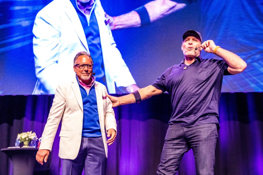 two men are standing next to each other on a stage .