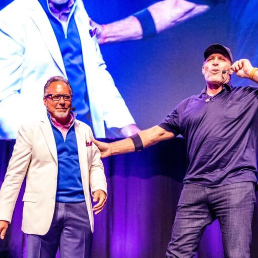 two men are standing next to each other on a stage .