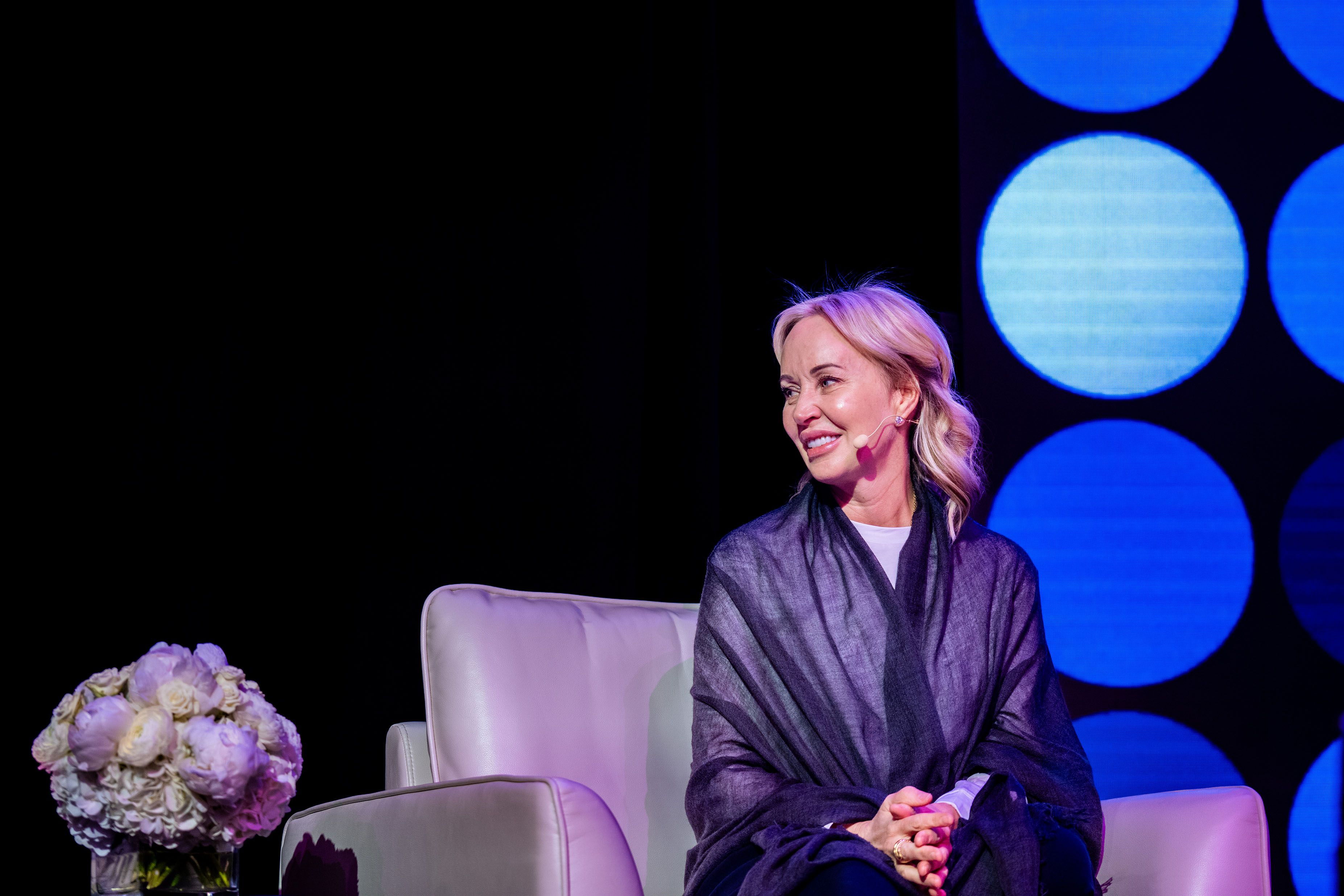 a woman is sitting in a chair on a stage .