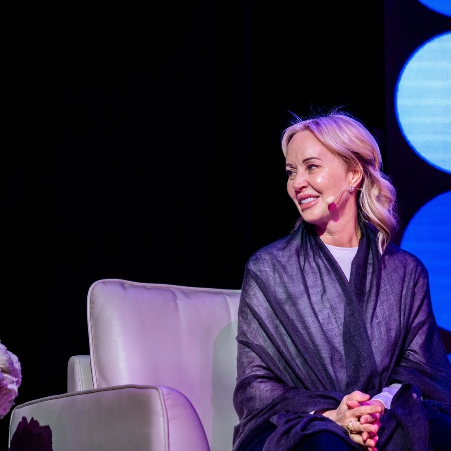 a woman is sitting in a chair on a stage .