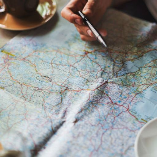 a person is sitting at a table looking at a map .