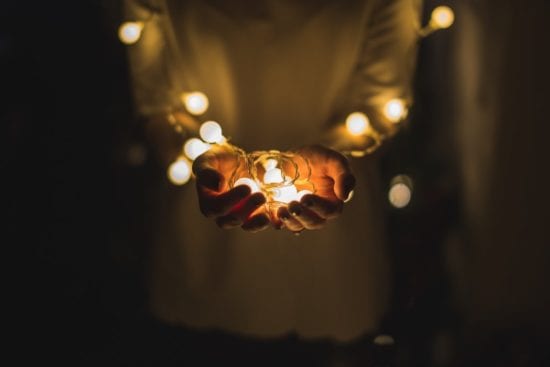 a person is holding a string of christmas lights in their hands .