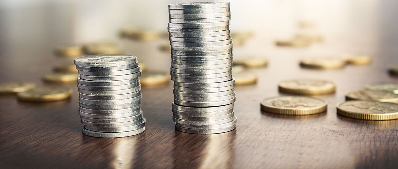 three stacks of coins are sitting on a wooden table .