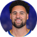 Klay Thompson a basketball player with a beard is smiling for the camera .
