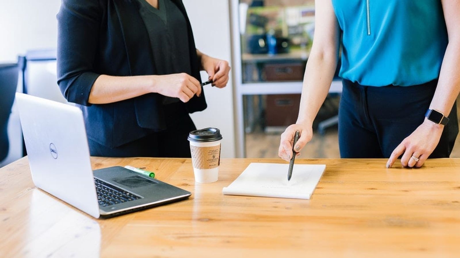 a man and a woman are shaking hands over a table .