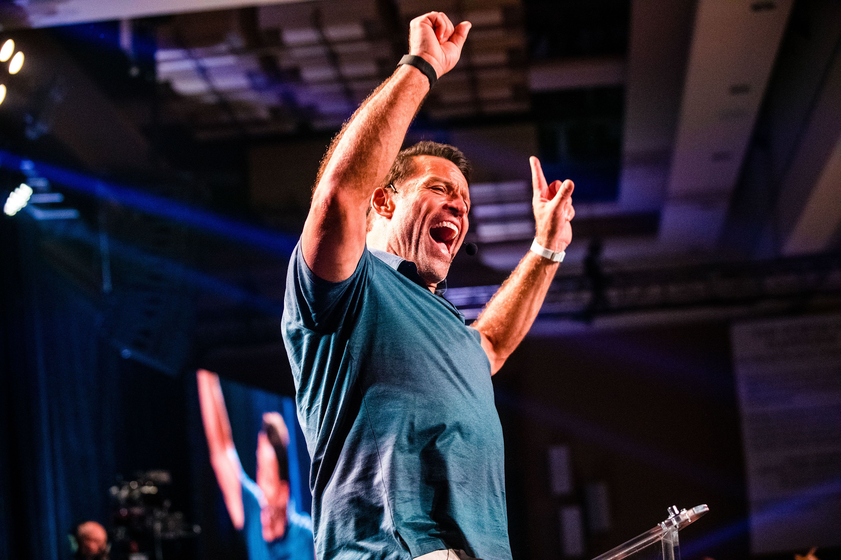 a man is standing on a stage with his arms in the air .