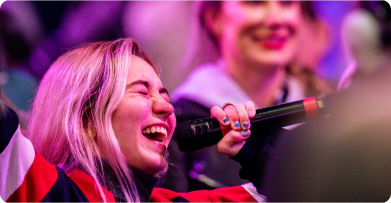 a woman is singing into a microphone while laughing .