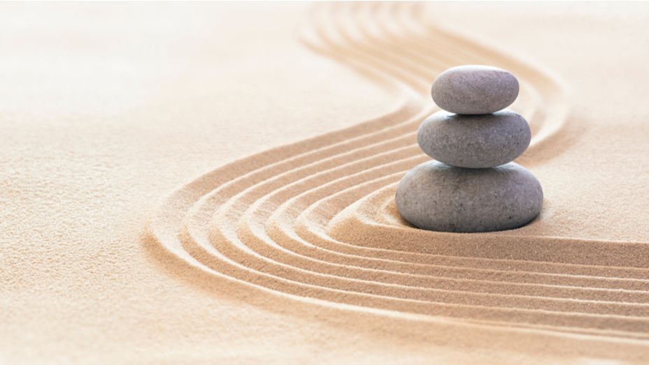 three rocks are stacked on top of each other in the sand .
