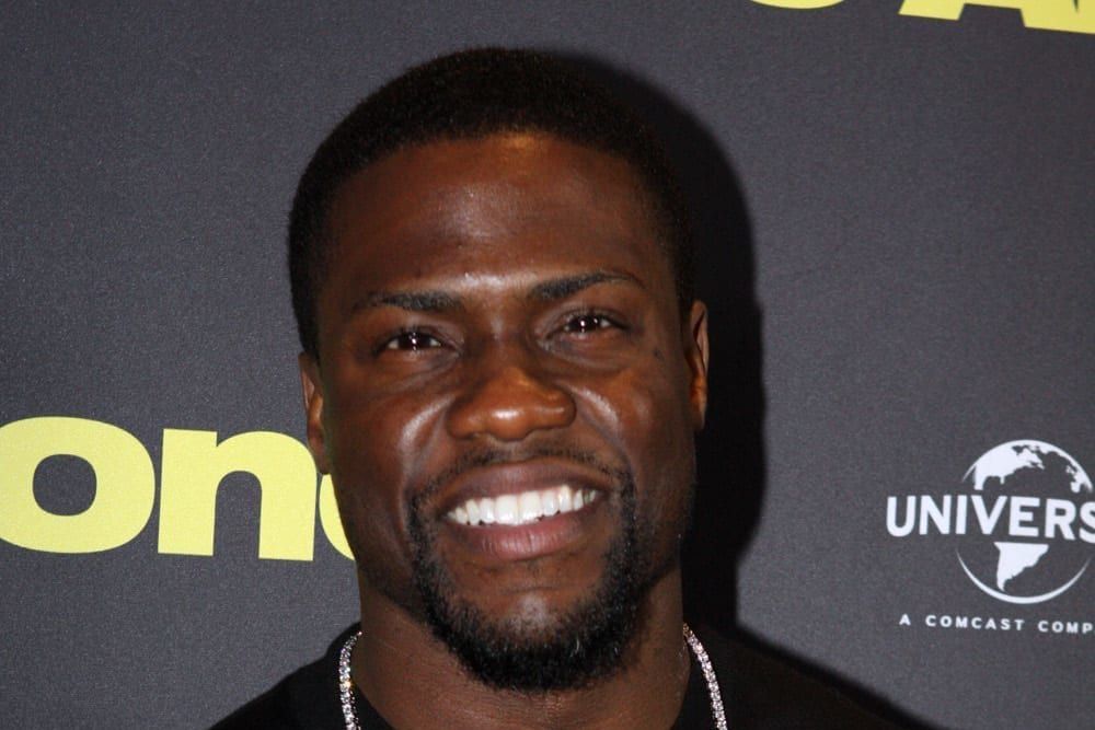 a man with a beard is smiling and wearing a black shirt .