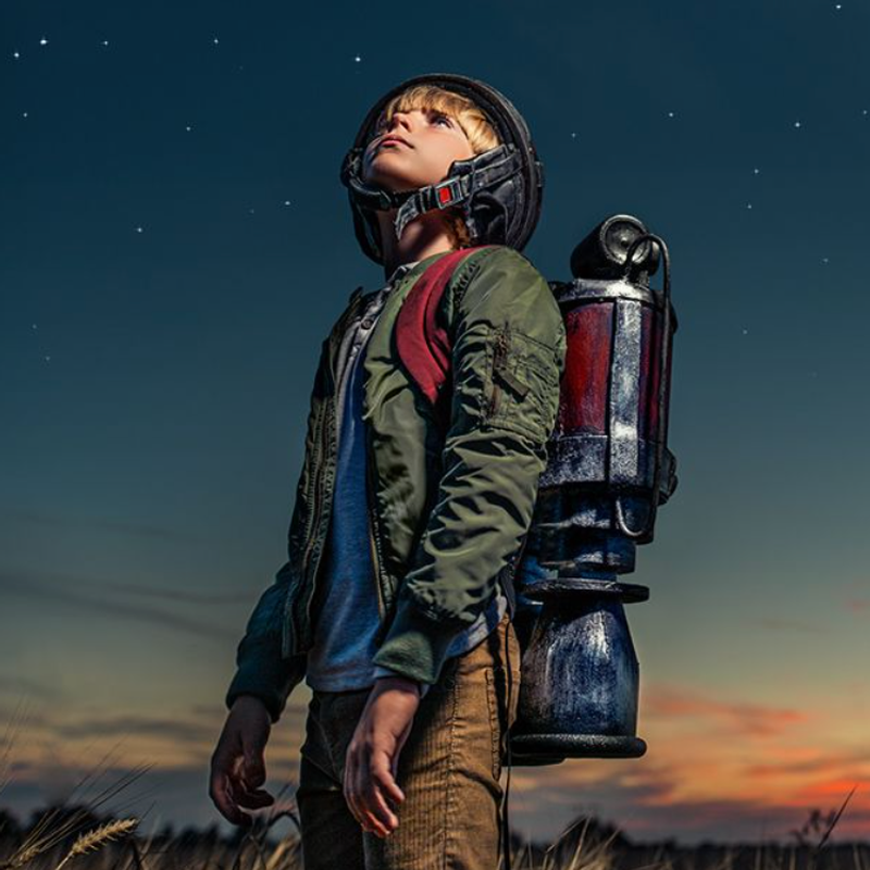 Finding solutions to global problems image of a young boy wearing a helmet and carrying a pretend rocket booster on his back looking into space