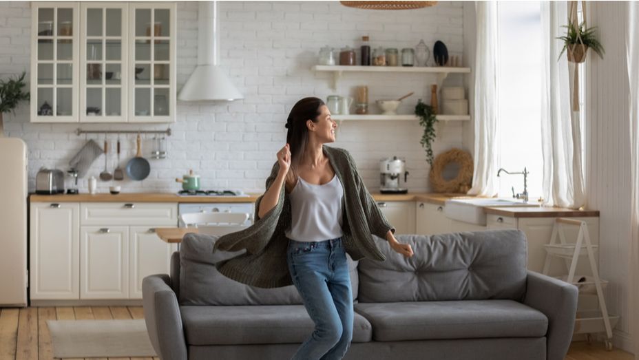 a woman is dancing on a couch in a living room .