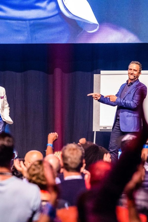 two men are standing on a stage in front of a crowd .