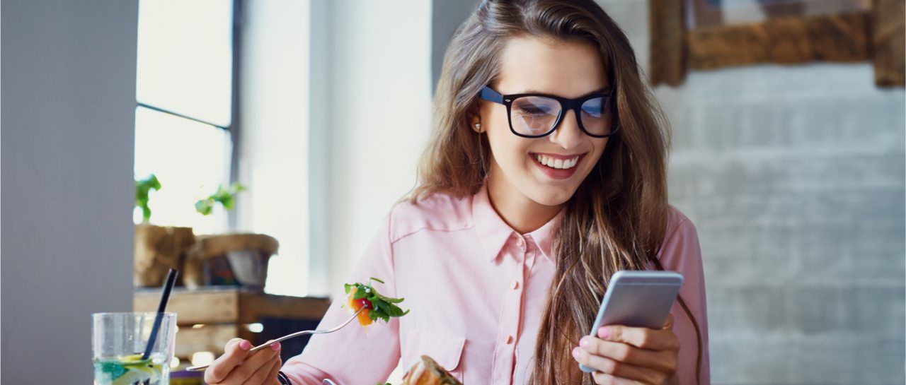 Achieving unstoppable energy image of woman eating healthy foods looking at phone