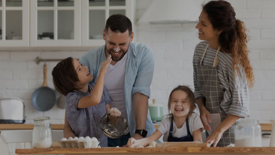 a family is preparing food together in the kitchen .