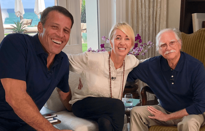 two men and a woman are posing for a picture in a living room