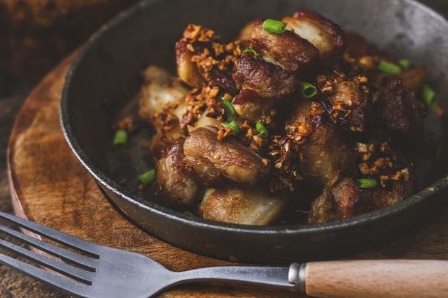 a close up of a plate of food with a fork on a wooden table .