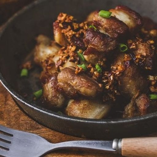 a close up of a plate of food with a fork on a wooden table .