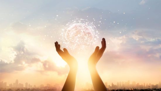 a person is holding a glowing brain in their hands .