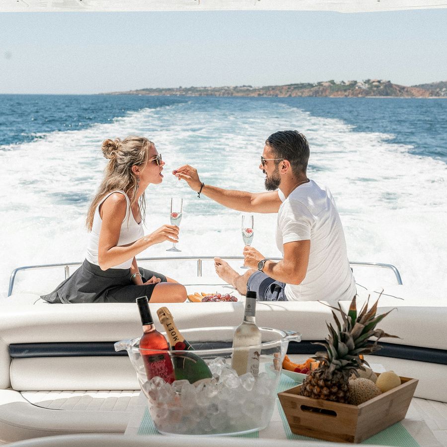 a man and a woman are drinking wine on a boat in the ocean .