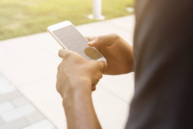 a person is holding a cell phone in their hands .