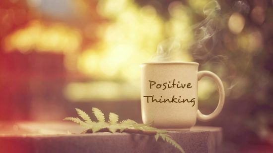 a cup of coffee with the words `` positive thinking '' written on it .