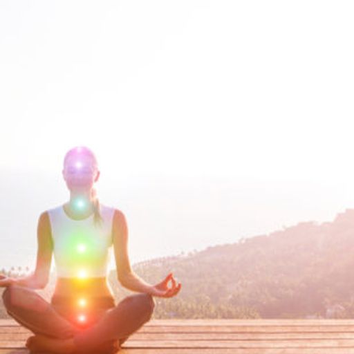 a woman is sitting in a lotus position on a wooden deck .