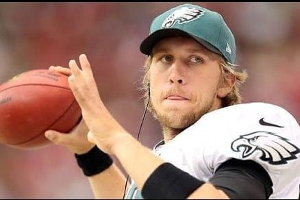 a man in a green hat is throwing a football .