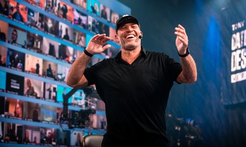 a man is standing on a stage with his hands in the air