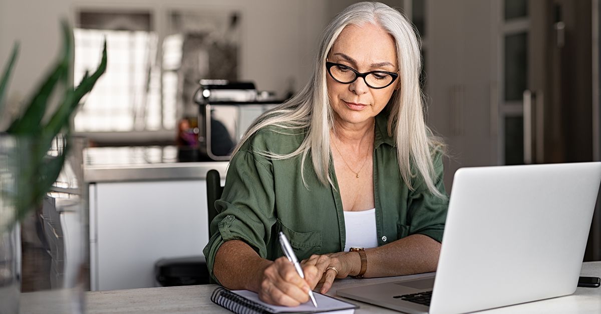 How to protect your business image of older woman writing notes in front of a laptop