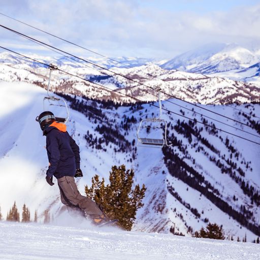 a man is snowboarding down a snow covered mountain .