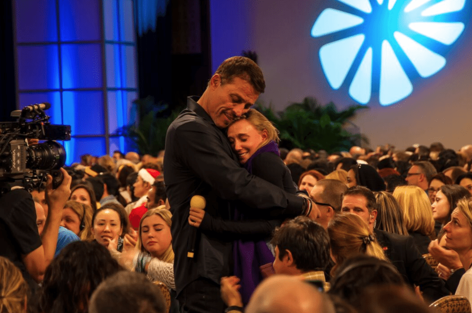a man and woman are hugging in front of a crowd