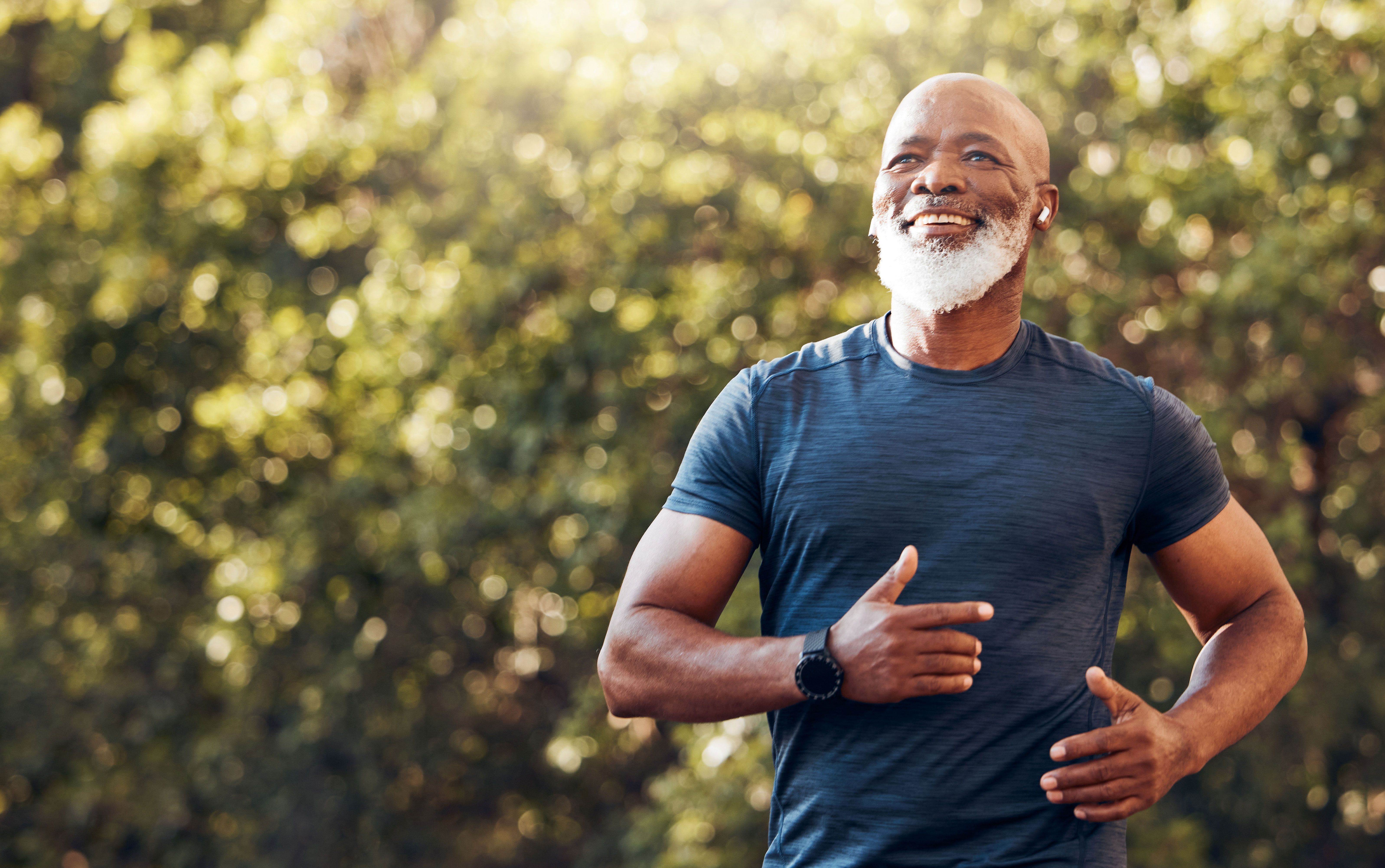 a man with a beard is running in a park .