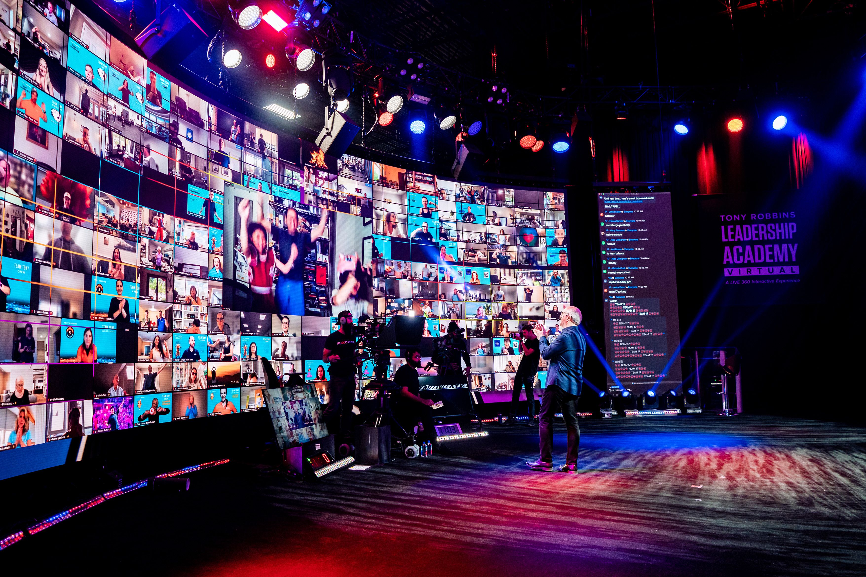 a man is standing on a stage in front of a large screen .