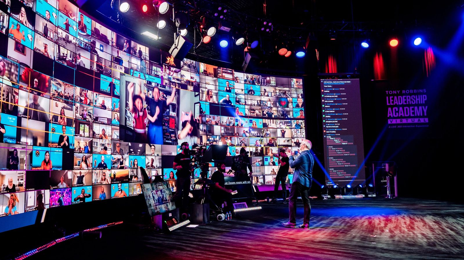 a man is standing on a stage in front of a large screen .