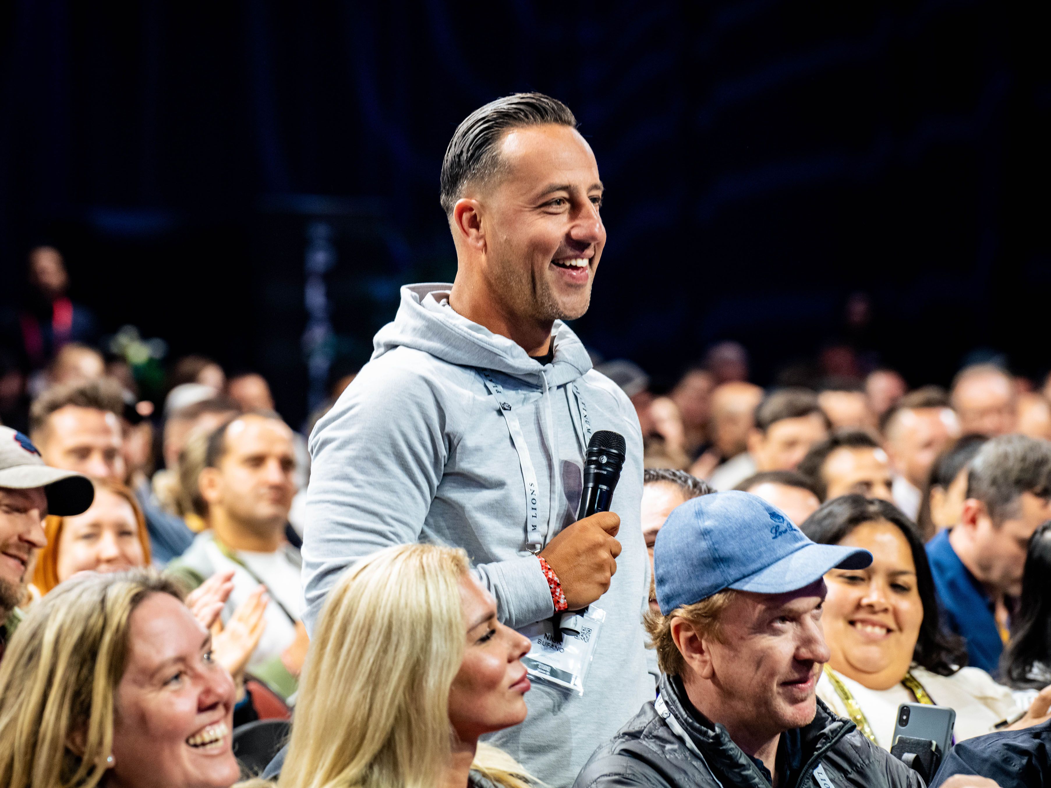 a man is holding a microphone in a crowd of people .